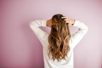 Woman checking thinning hair before hair restoration at J9 Clinic in Houston